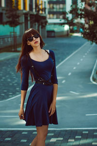 Young woman standing on street in city