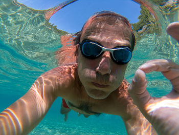 Portrait of shirtless man swimming in sea