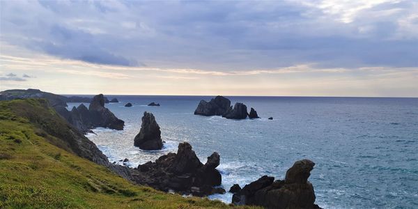 Scenic view of rocks in sea against sky