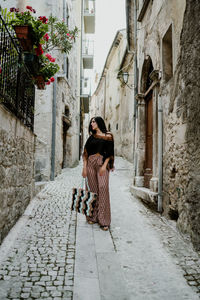 Full length of woman on street amidst buildings