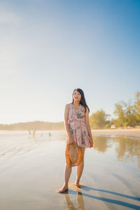 Full length of woman standing in water against clear sky