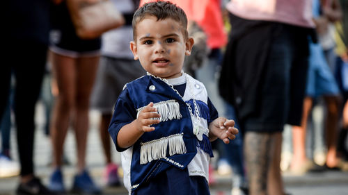 Close-up of boy standing against blurred background