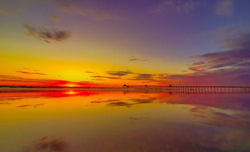 Scenic view of sea against dramatic sky during sunset