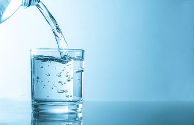 Glass of water against blue background