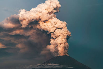 Smoke emitting from volcanic mountain against sky