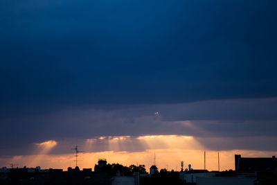 Silhouette cityscape against sky during sunset