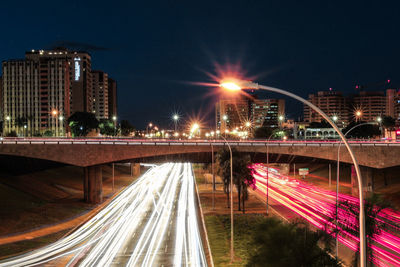 Light trails on bridge in city at night