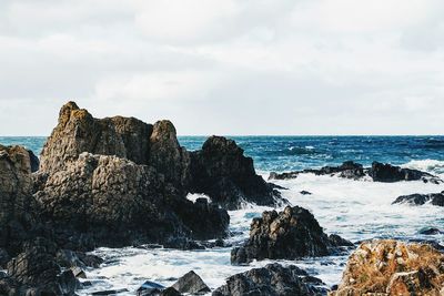 Rock formation in sea against sky