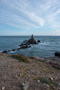 Rocks on sea shore against sky