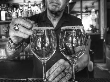 Midsection of man holding wineglass