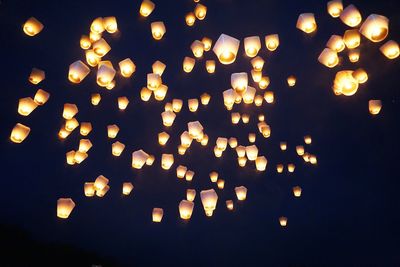Low angle view of illuminated lanterns against sky