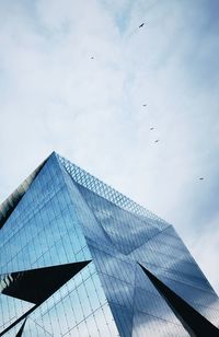 Low angle view of birds flying against sky