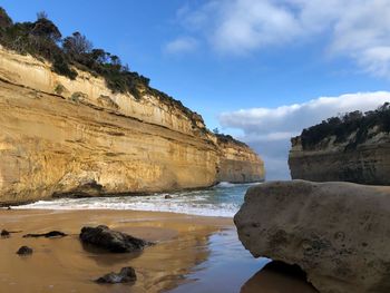 Scenic view of rocks on beach against sky