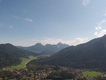 Scenic view of townscape by mountains against sky