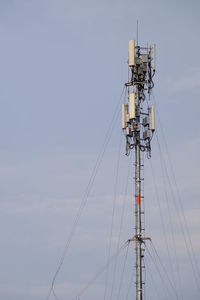 Low angle view of communications tower against sky