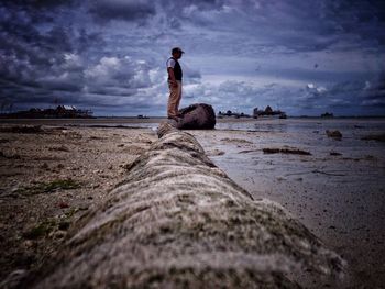 Statue on beach against sky