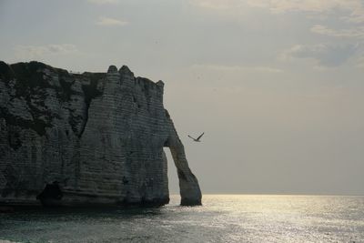 Rock formations by sea against sky