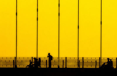 Silhouette man standing by sea against clear sky during sunset