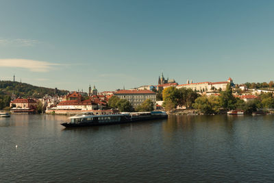 Scenic view of river by buildings against sky in city