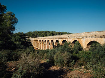 Arch bridge against clear blue sky