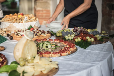 Midsection of man holding plates by food on table