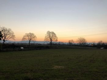 Scenic view of field against clear sky during sunset