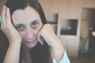 Close-up portrait of depressed woman at home