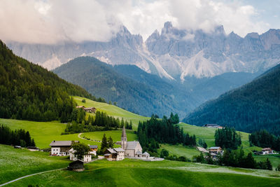 Houses on field by mountains against sky