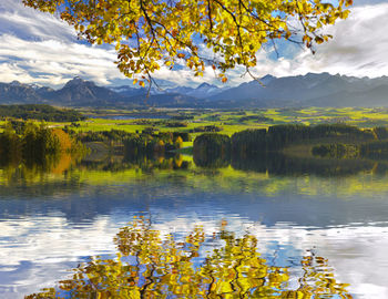 Scenic view of lake and mountains against cloudy sky