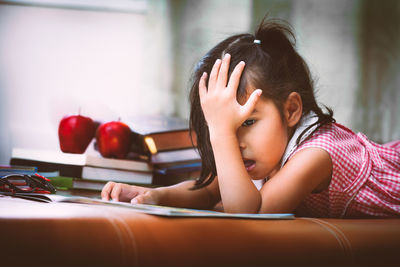 Girl reading book on couch at home