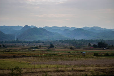 Scenic view of field and mountains against sky