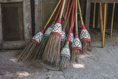 Handmade brooms leaning against house