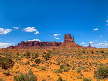 Rock formations on landscape against blue sky