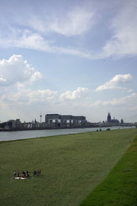 Scenic view of river by buildings against sky