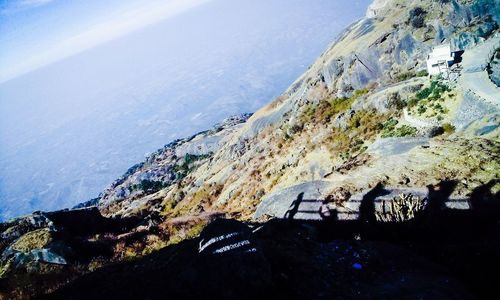 Scenic view of sea by mountain against sky