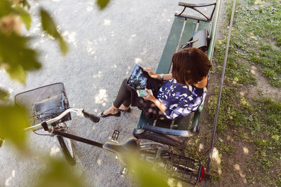 High angle view of businesswoman using digital tablet on park bench