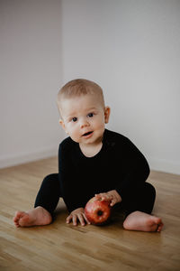 Portrait of cute baby boy lying on floor at home