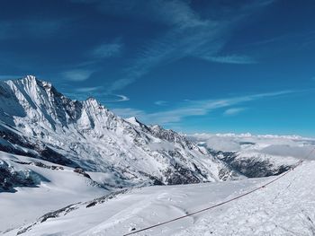 Scenic view of snowcapped mountains against blue sky
