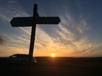 Silhouette cross against sky during sunset