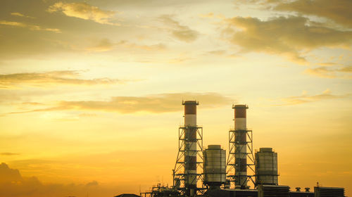 Factory against sky at sunset