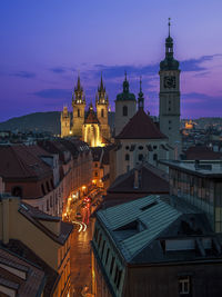 Illuminated street amidst buildings in city at night