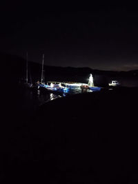 Boats moored in marina at night