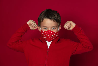 Close-up portrait of boy against red background