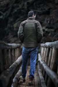 Rear view of man standing on wood