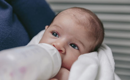 Close-up of mother feeding milk to daughter at home