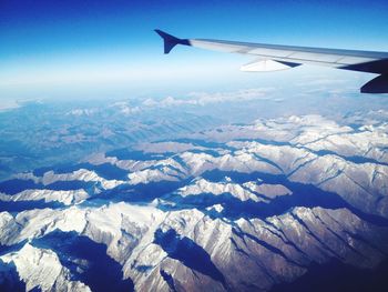 Cropped airplane flying over snowcapped mountains