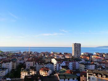 High angle view of townscape by sea against sky