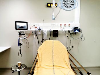 Close-up of electric lamp on bed against wall