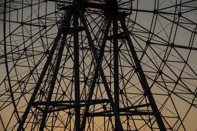 Low angle view of silhouette electricity pylon against sky