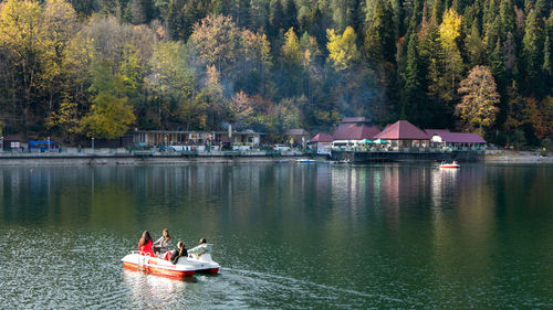 People on lake against trees
